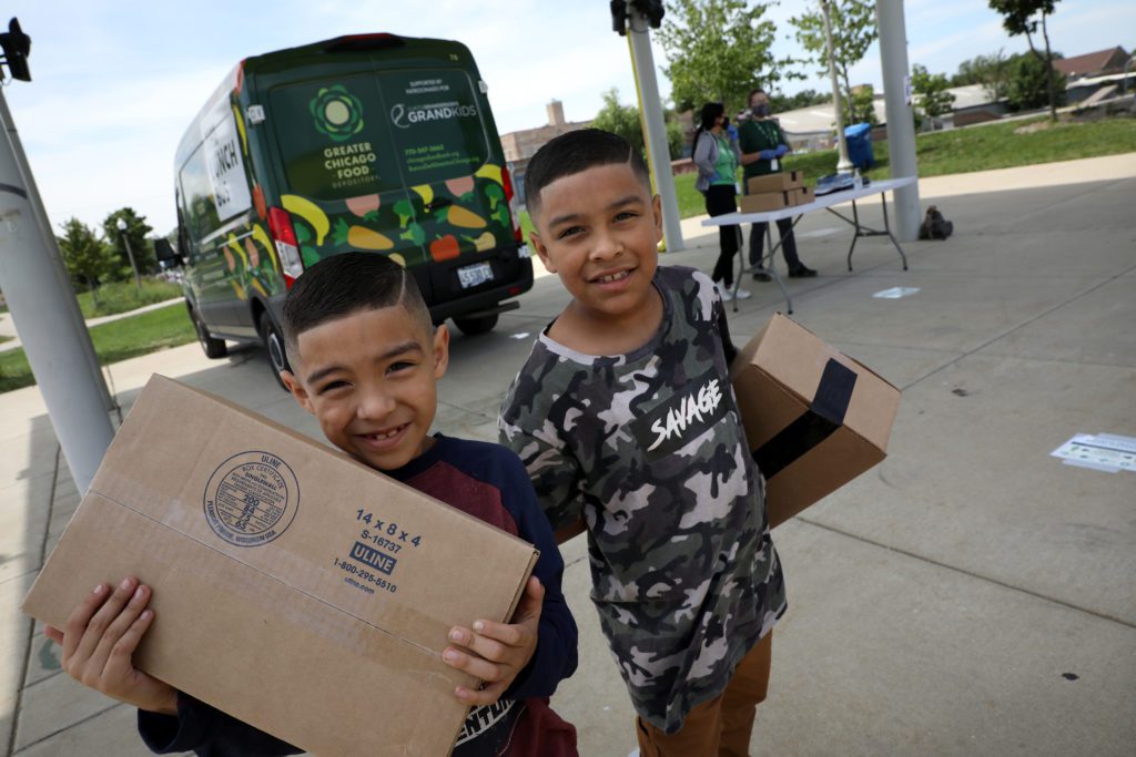 Brothers Fabian and Daniel Lobato pick up meals from the La Villita Park Lunch Bus stop in South Lawndale.