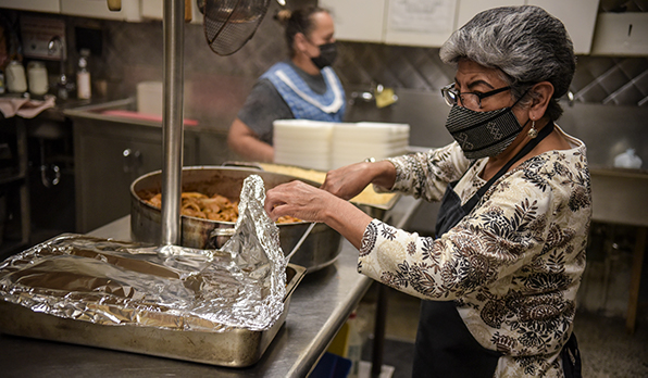 Gloria Flores, St. Pius volunteer, preparing food for the day.