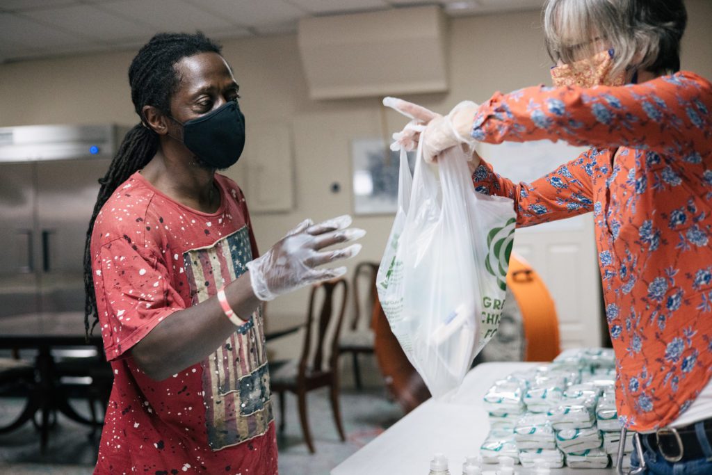 A volunteer helps a guest at the Above and Beyond food pantry.