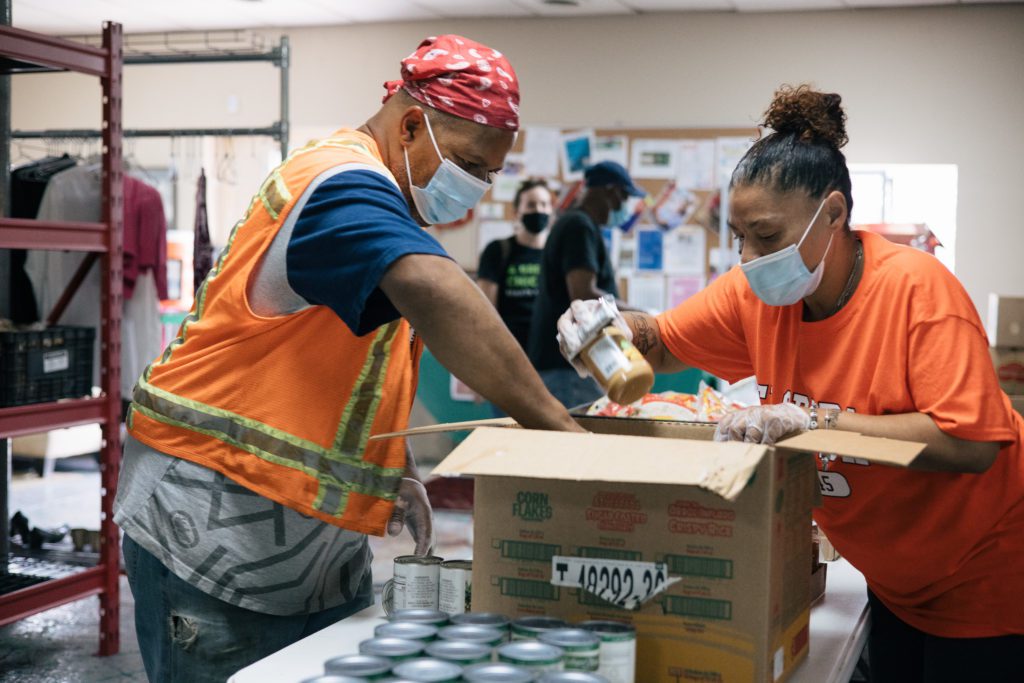 With the help of a volunteer, Alan Sutton boxes his groceries.