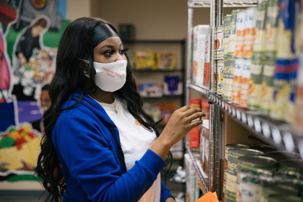 Volunteer Niya Scott helps pick out groceries for a guest at the Free-N-Deed Market.