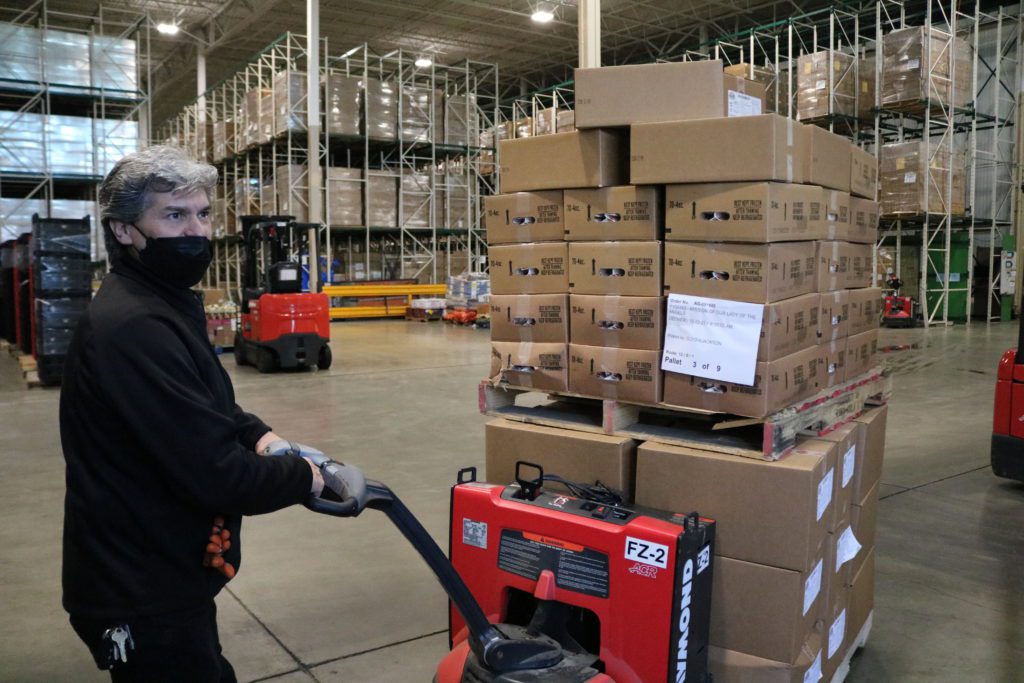 Efrain Reyes loads a pallet of hams onto his truck for delivery.