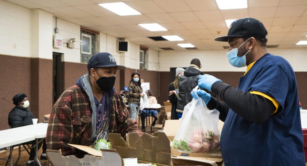 A volunteer helps a guest during a recent distribution at the Coppin food pantry.