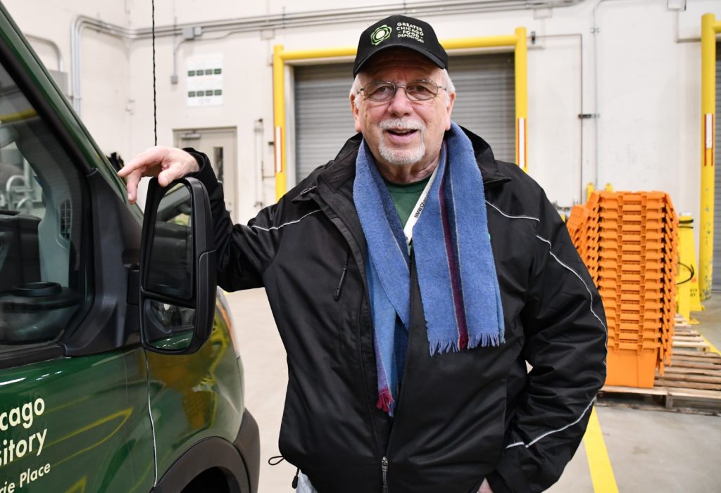 Bill Engels poses for a photo next to a Food Depository truck