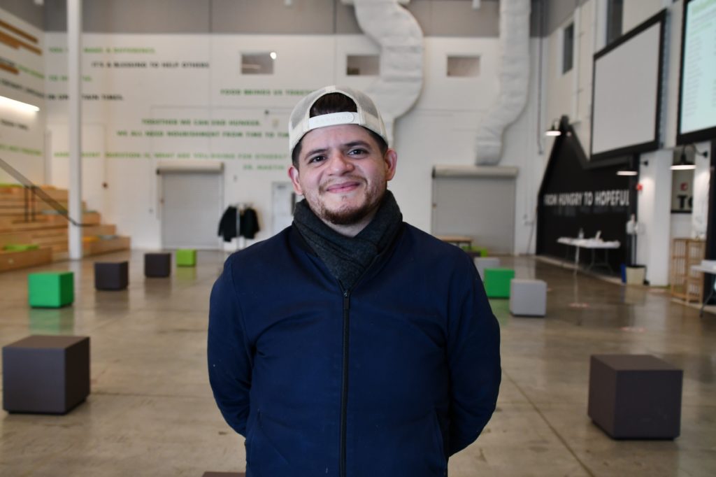Eddy Gonzalez poses for a photo in the Food Depository's volunteer orientation room.