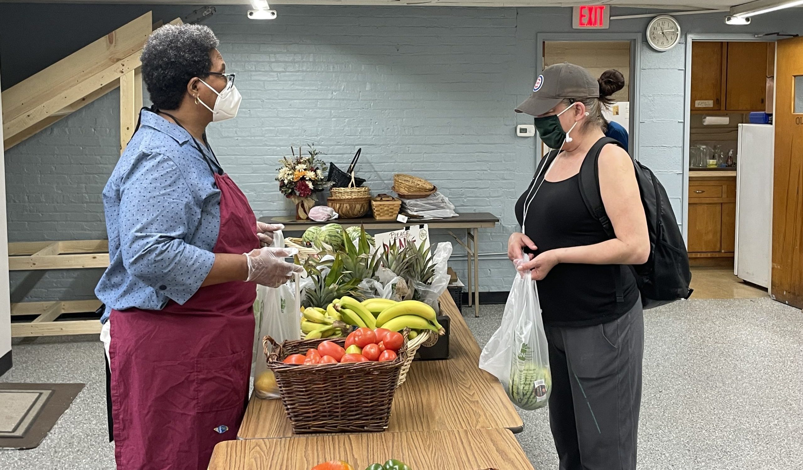 Shirley Redmond helps guest Julie Stokes pick out produce.