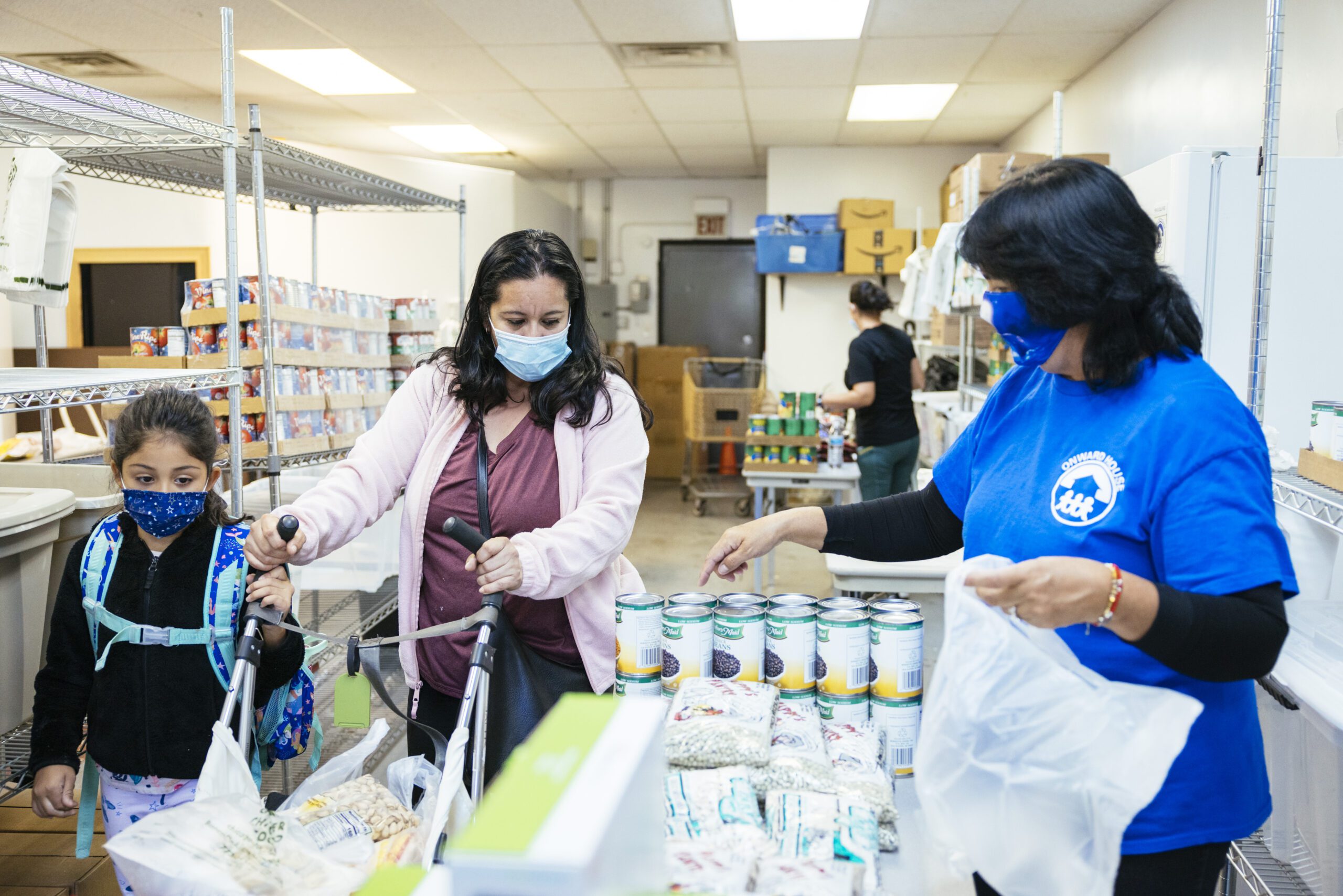 a woman and her child consider food at a food pantry