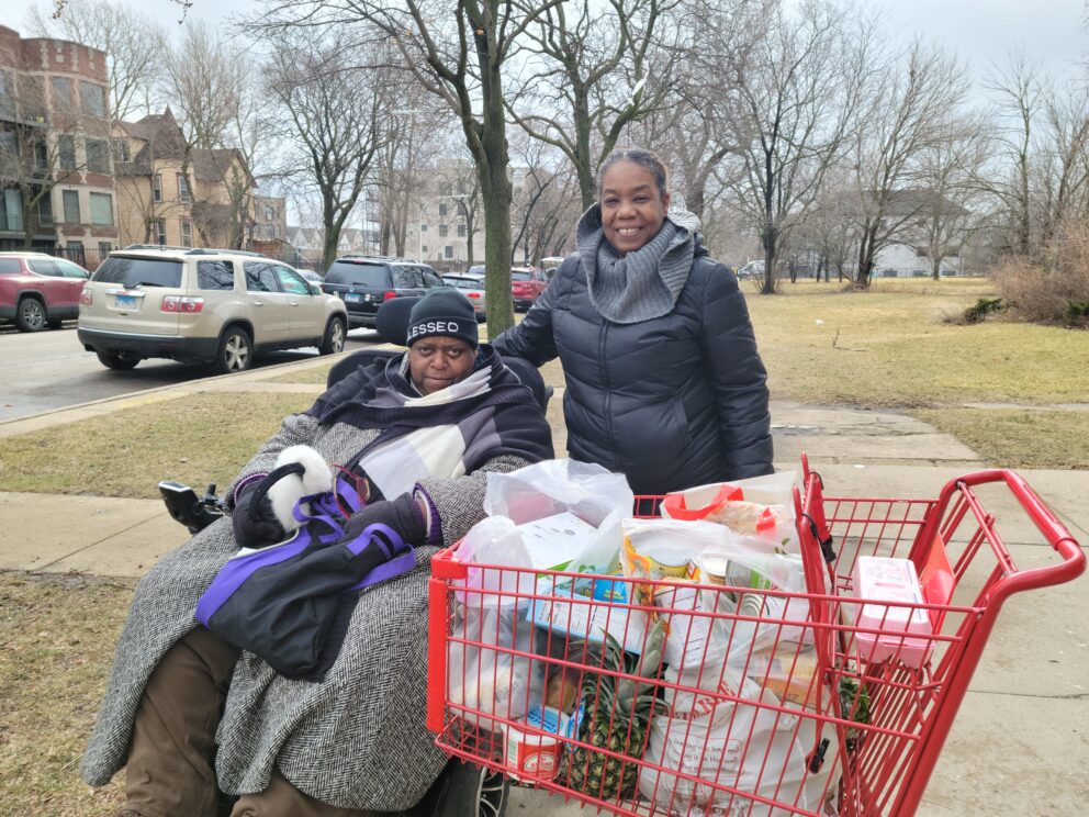 two women with a shopping cart full of food