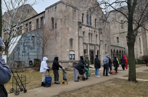 people stand in line for a food pantry at a church