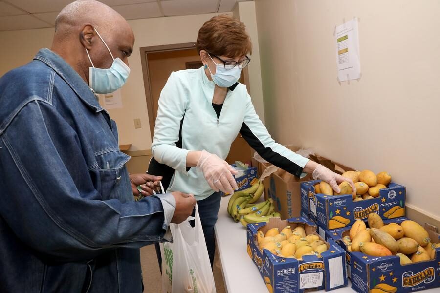 Two people selecting food at pantry