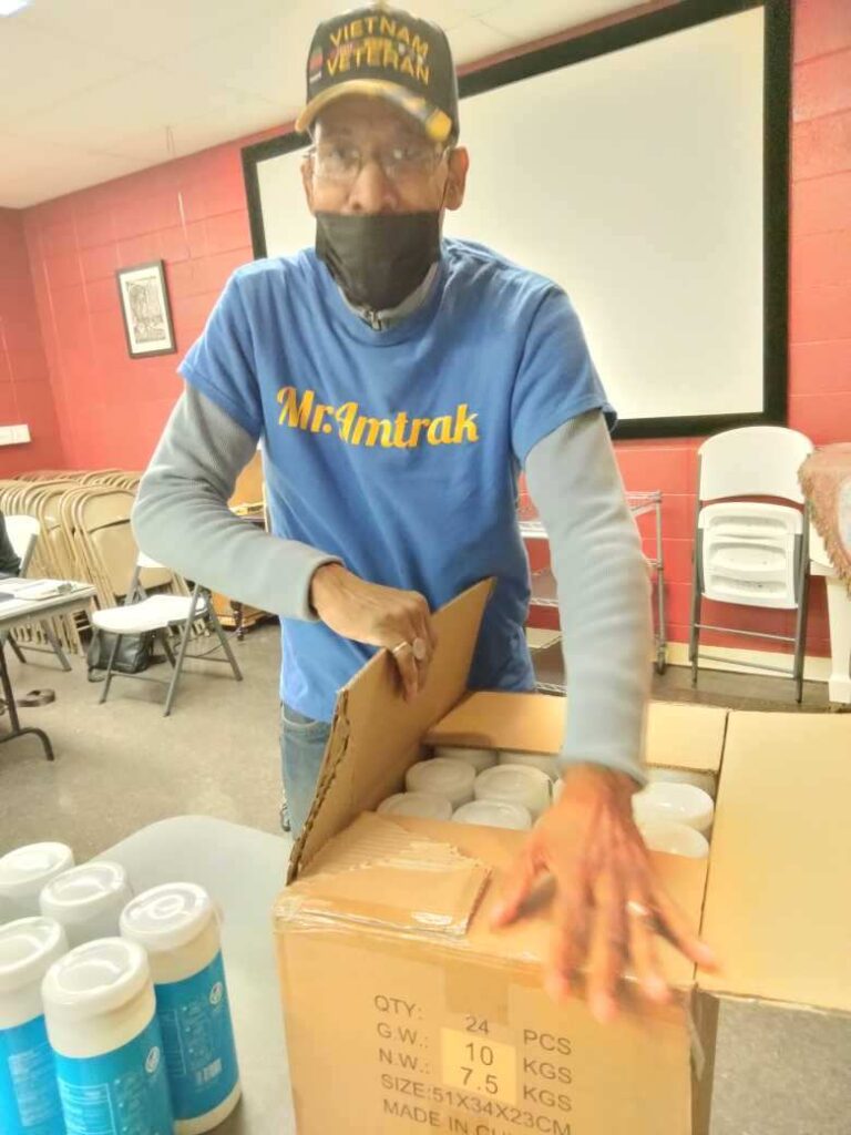 a volunteer unpacks a box of food