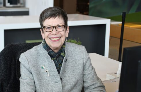 a woman in glasses smiles at the camera