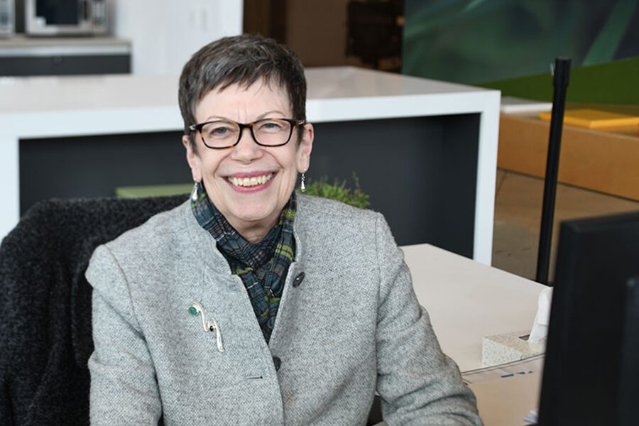 a woman in glasses smiles at the camera