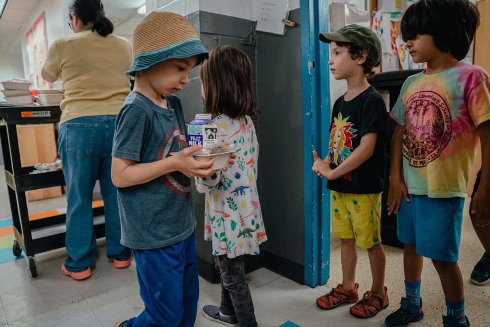 kids line up to receive a packaged breakfast