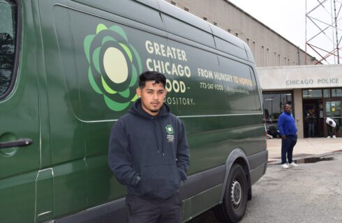 A Food Depository driver stands next to a delivery van.