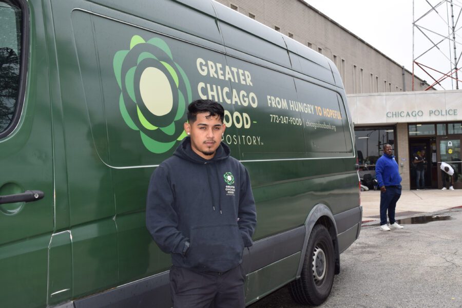 A Food Depository driver stands next to a delivery van.