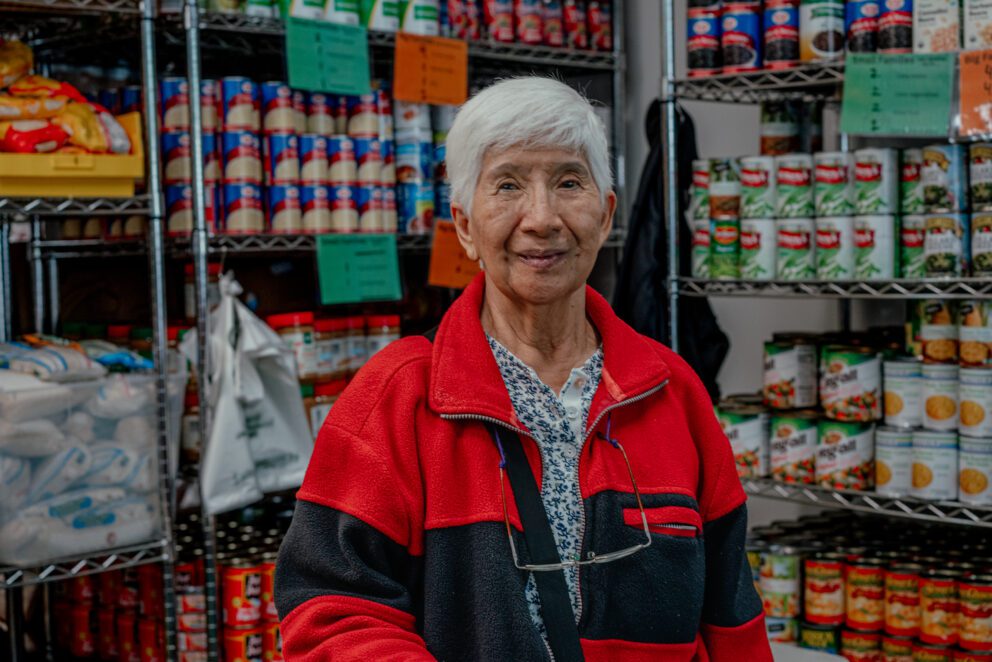 a woman at a food pantry smiles at the camera