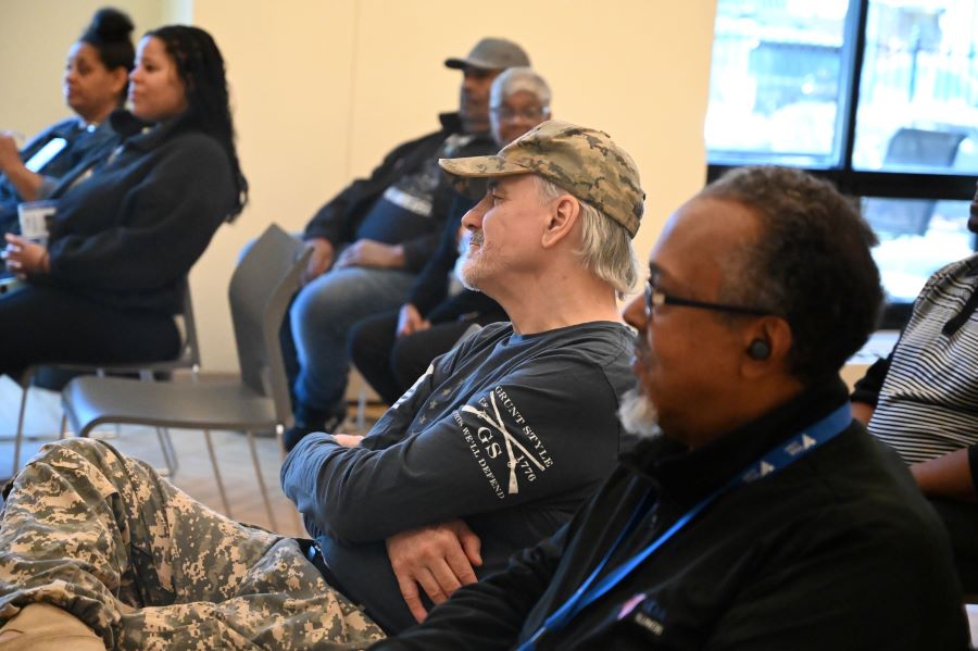 A veteran sits and watches Hightower's cooking demonstration