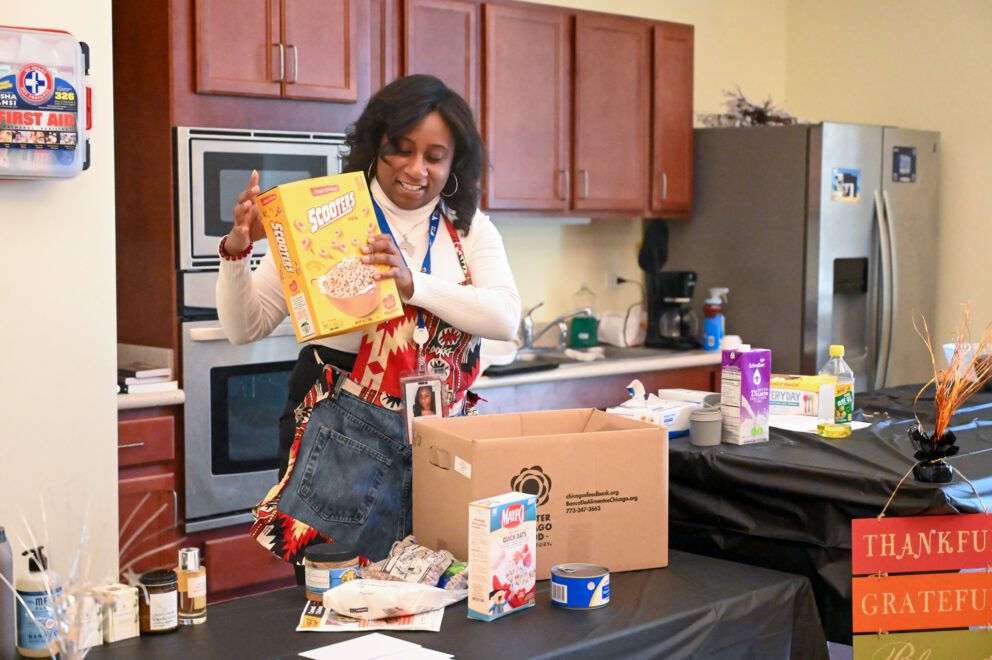 Lauren Hightower pulls items out of the CSFP box to demonstrate what items the veterans the receive