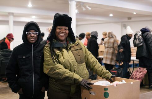 Jennifer and Emar hold a box of food