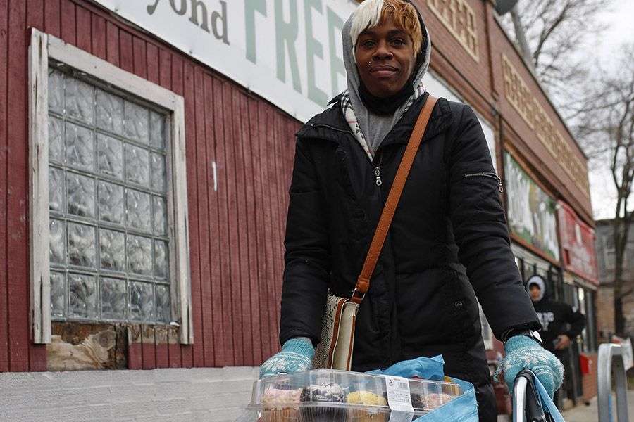 a woman stands in front of a food pantry