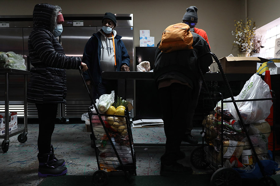 people stand in line at a food pantry