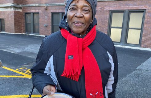 a woman holding a pumpkin pie smiles at the camera