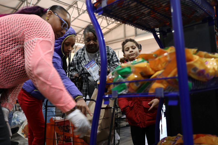 Jaqueline Maxson and her grandchildren pick out food from the pantry.