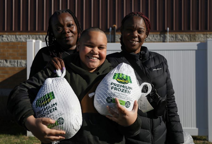 A family poses with their turkeys at the Hattie B. food pantry.