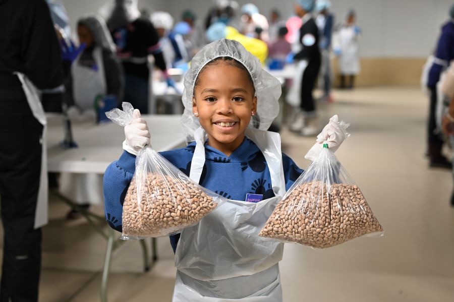 Young girl from Jack and Jill holds bags of beans she helped to repack