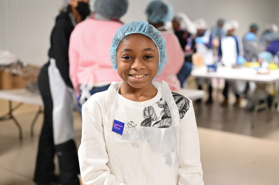 Jack and Jill member Makenzie Ward takes a break from repacking beans to pose for a photo in the repack room.