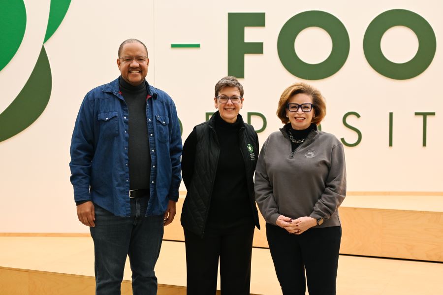 Michael Strautmanis, Kate Maehr, and Valerie Jarrett pose for a picture together in the Food Depository's volunteer orientation room.