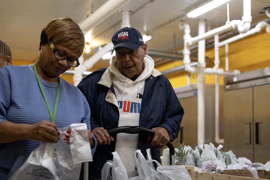 A volunteer helps Gwendolyn Traylor picks out food from the pantry.