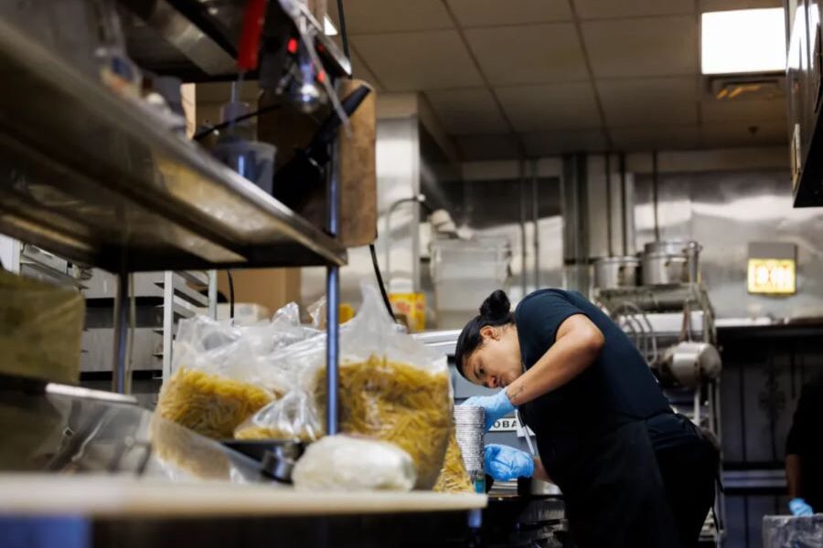 A woman prepares food in a kitchen.