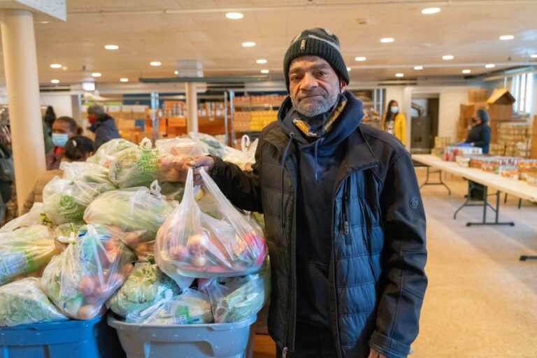 Man receiving bag of fresh produce. 