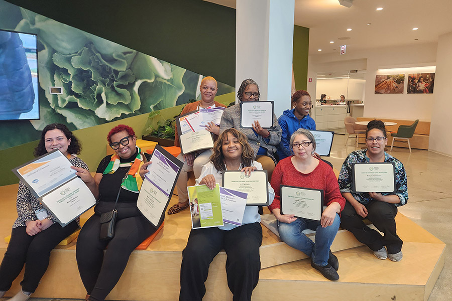 students proudly hold the certificates they earned