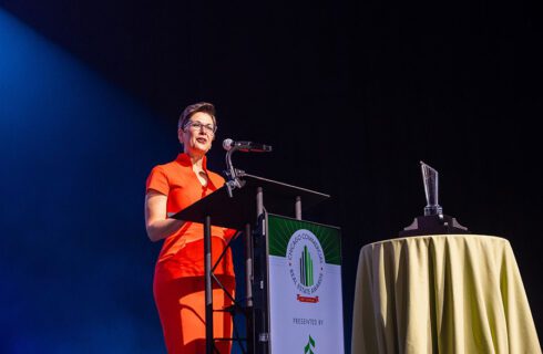 a woman stands at a podium at an event