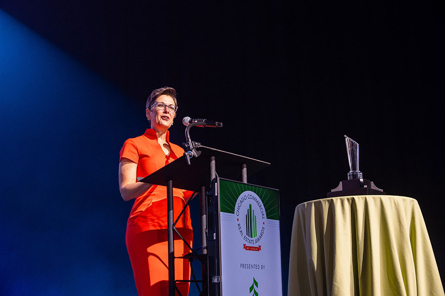 a woman stands at a podium at an event