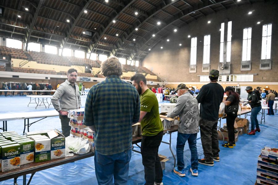 A line of people standing in front of a table.