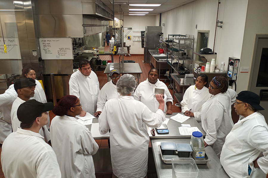 a chef talks to a group of cooking students