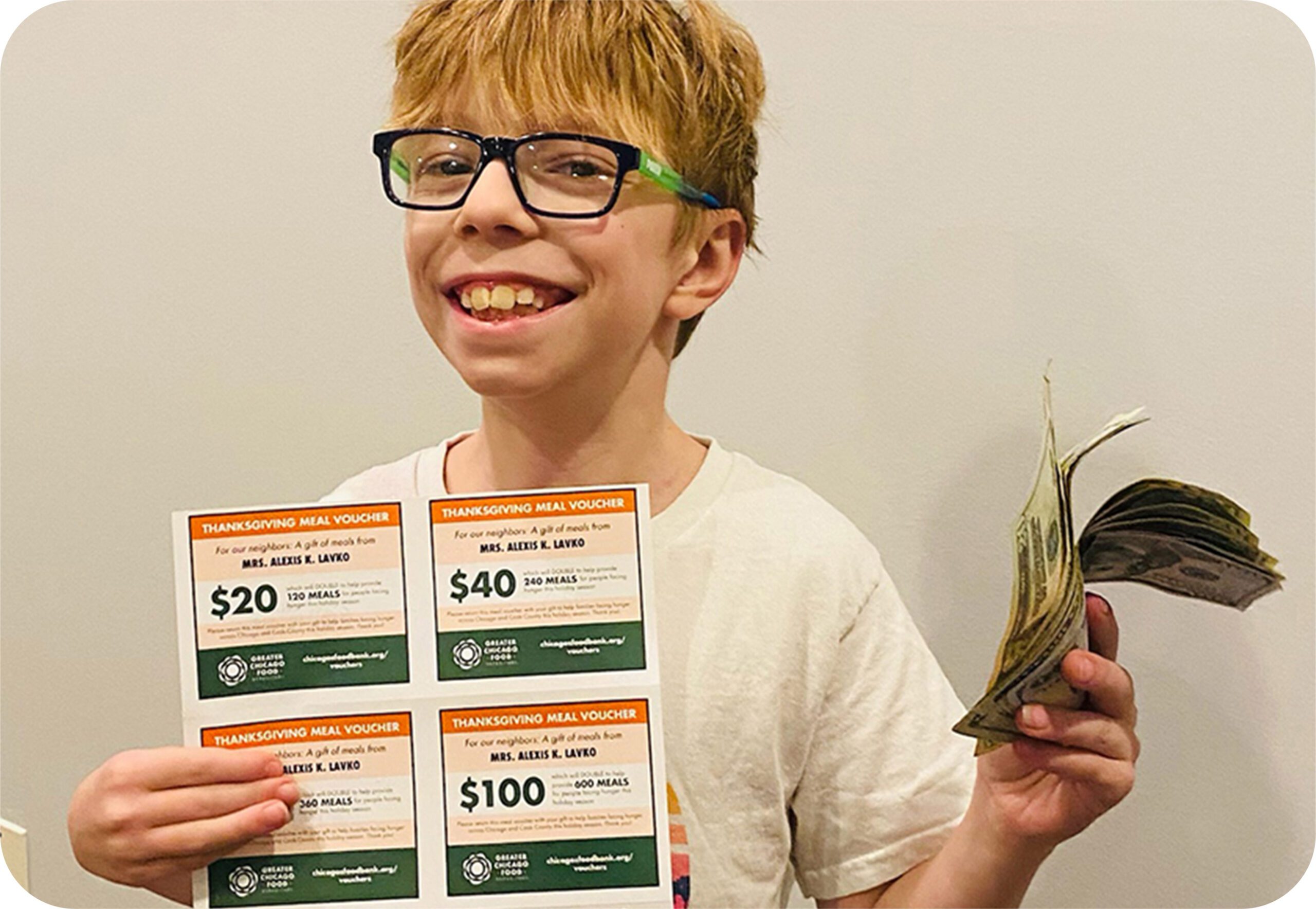 This is Ray, 11, holding up his Thanksgiving Meal Vouchers.