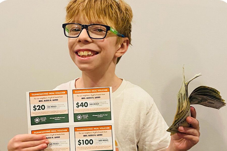 This is Ray, 11, holding up his Thanksgiving Meal Vouchers