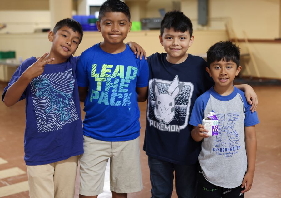 Four boys smile at the camera.