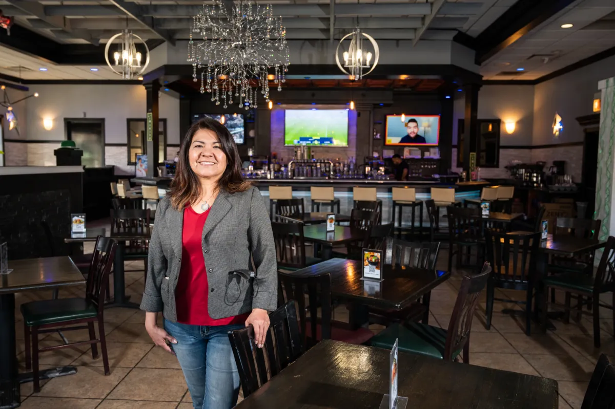 A woman stands in a restaurant.