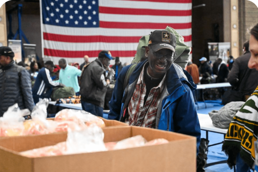 Veteran Timothy smiles as he selects fresh produce at a distribution site.