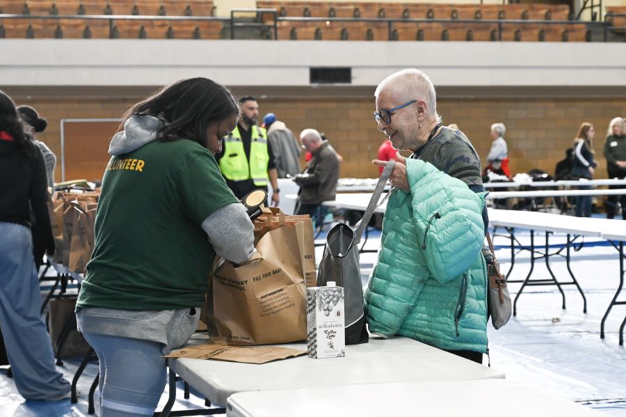 Karen McLeisch receives a bag of groceries from a Food Depository volunteer.