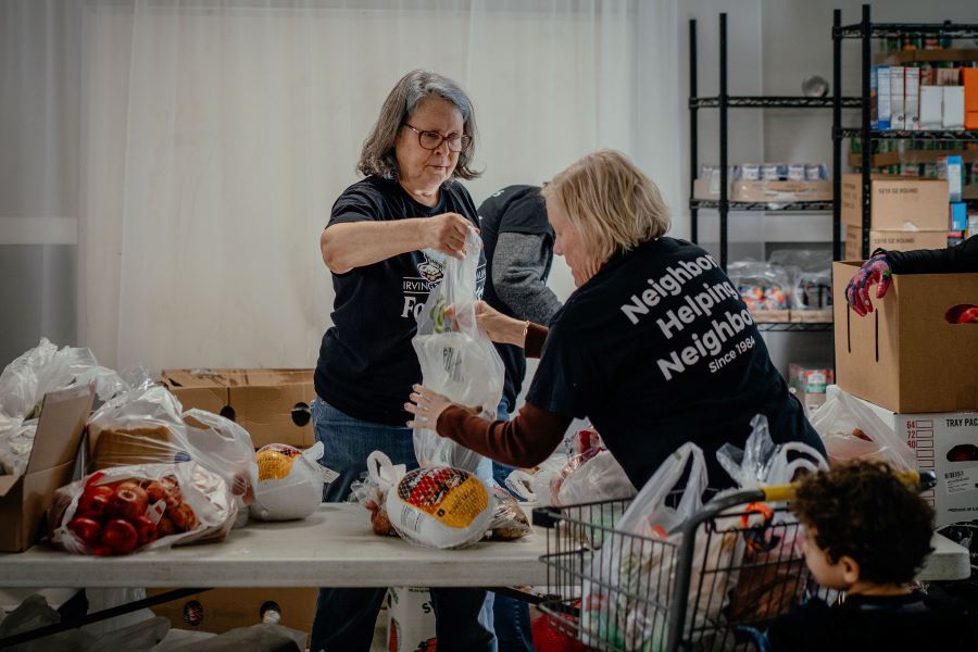 Two women prepare food at a pantry