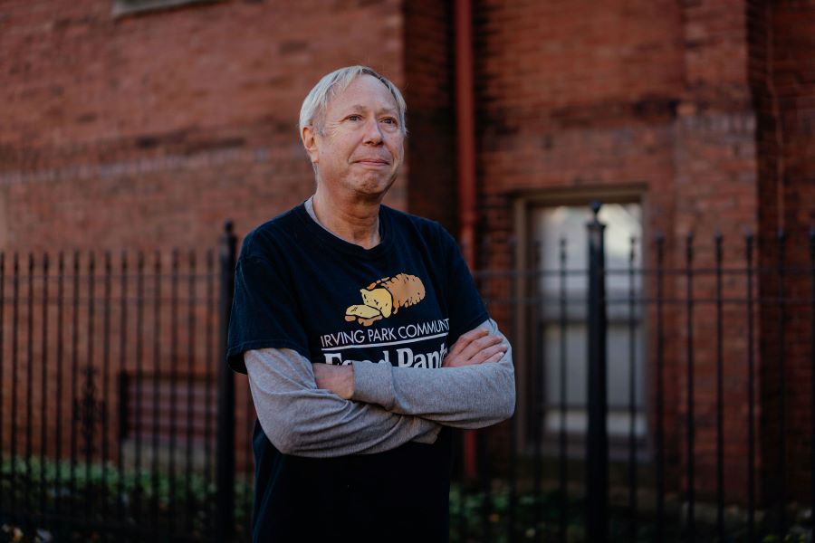 A man with folded arms looks into the distance