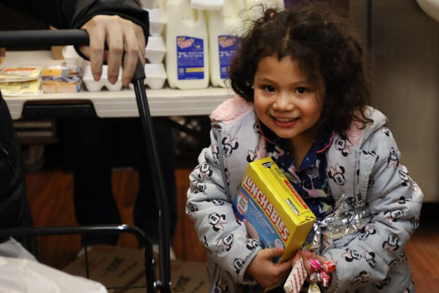A young child holds groceries