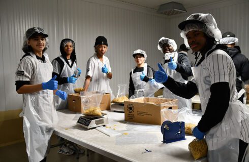 boys who are volunteering smile at the camera, flashing thumbs up